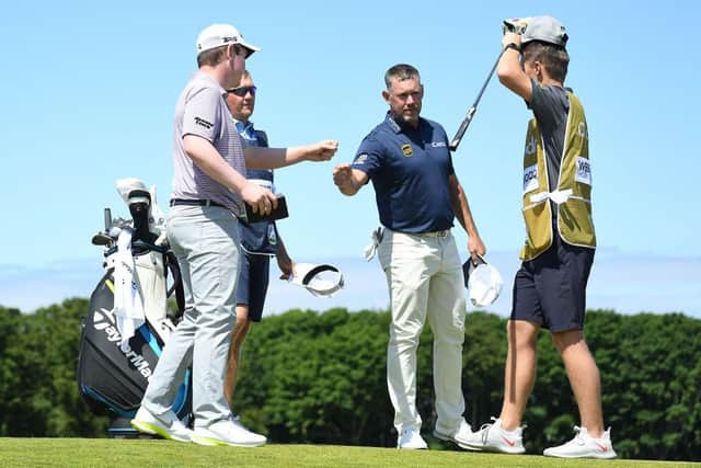 Lee Westwood and Bob MacIntyre touch knuckles at the end of their round in East Lothian. Mark Runnacles/Getty Images.