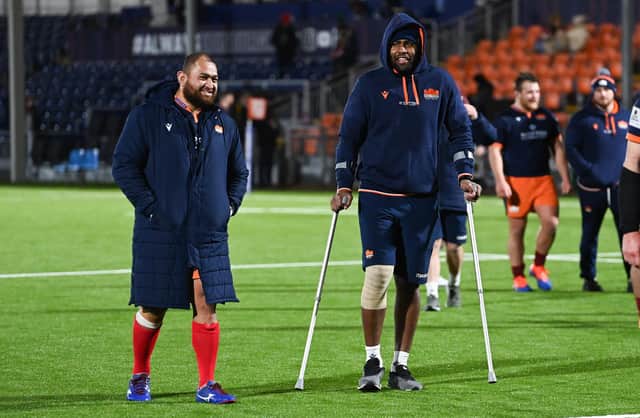 Viliame Mata, right, leaves the field on crutches with Edinburgh team-mate Lee-Roy Atalifo. (Photo by Paul Devlin / SNS Group)