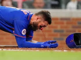 Kevin Pillar of the New York Mets takes a moment as his nose bleeds after being hit by a pitch against the Atlanta Braves. Picture: Todd Kirkland/Getty Images