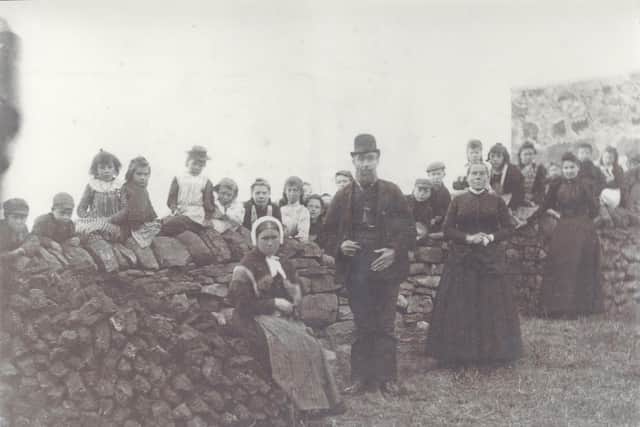 Scoraig Public School in 1897. Mary Ann Mackenzie is pictured third from left on the wall. The peat stack was added to every day by pupils. PIC : Ullapool Museum.