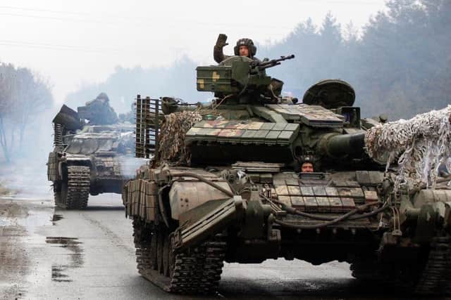 Ukrainian servicemen ride on tanks towards the front line with Russian forces in the Lugansk region of Ukraine. - Ukrainian forces fought off Russian troops in the capital Kyiv on the second day of a conflict that has claimed dozens of lives, as the EU approved sanctions targeting President Vladimir Putin.
