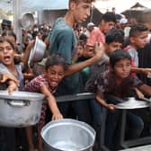 Palestinians gather to receive cooked meals from a food distribution centre in the Nuseirat refugee camp in the central Gaza Strip. Picture: Eyad Baba/AFP via Getty Images
