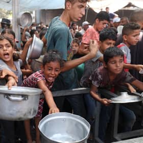 Palestinians gather to receive cooked meals from a food distribution centre in the Nuseirat refugee camp in the central Gaza Strip. Picture: Eyad Baba/AFP via Getty Images