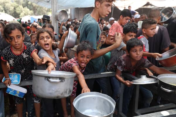 Palestinians gather to receive cooked meals from a food distribution centre in the Nuseirat refugee camp in the central Gaza Strip. Picture: Eyad Baba/AFP via Getty Images