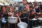 Palestinians gather to receive cooked meals from a food distribution centre in the Nuseirat refugee camp in the central Gaza Strip. Picture: Eyad Baba/AFP via Getty Images