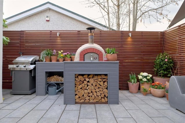 Wood fired outdoor oven and log store.