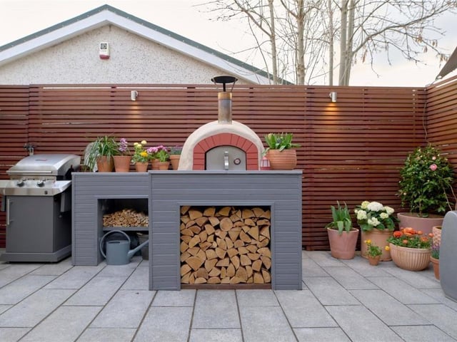 Wood fired outdoor oven and log store.