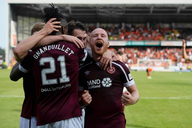 Hearts players celebrate after Armand Gnanduillet made it 2-0 at Tannadice.