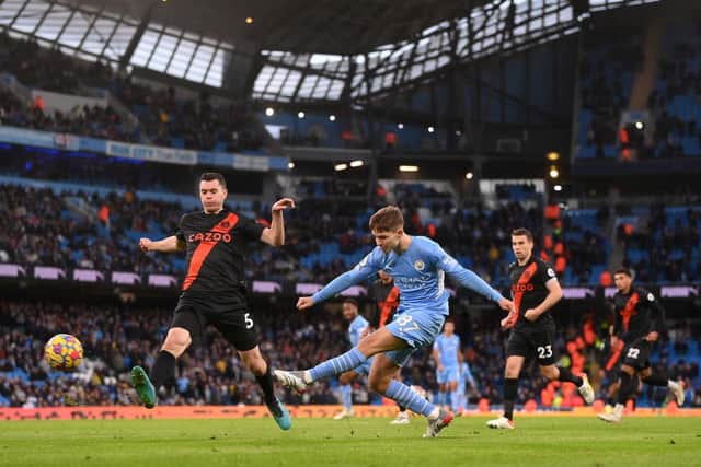 James McAtee of Manchester City shoots whilst under pressure from Everton's Michael Keane. (Photo by Laurence Griffiths/Getty Images)