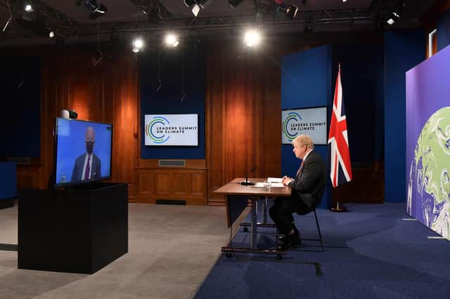 Boris Johnson and Joe Biden, on screen, take part in the opening session of the virtual summit on climate change organised by the US President (Picture: Justin Tallis/pool/AFP via Getty Images)