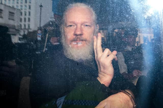 Julian Assange gestures to the media from a police vehicle after his arrest at the Ecuadorian Embassy in London in 2019 (Picture: Jack Taylor/Getty Images)
