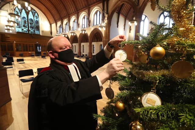 The Very Rev Dr Derek Browning puts the final touches on the Christmas tree inside Morningside Parish Church