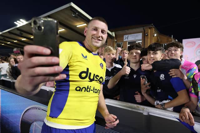 Finn Russell of Bath Rugby takes a selfie with fans following the Gallagher Premiership Rugby match against Newcastle Falcons.