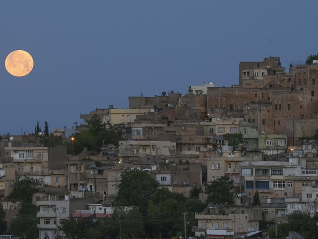 A full moon rises above the historical city centre of Mardin, famous with its stone houses, in southeastern Turkey, early Monday, May 16, 2022. (AP Photo/Emrah Gurel)