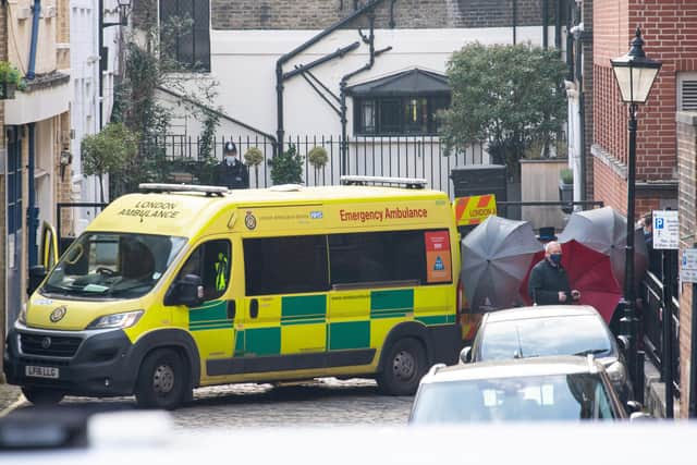 Staff shield the exit with umbrellas, alongside an ambulance, outside the rear of the King Edward VII Hospital in London where the Duke of Edinburgh was admitted on Tuesday. Picture: PA
