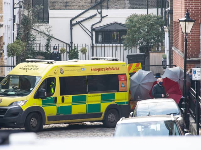 Staff shield the exit with umbrellas, alongside an ambulance, outside the rear of the King Edward VII Hospital in London where the Duke of Edinburgh was admitted on Tuesday. Picture: PA