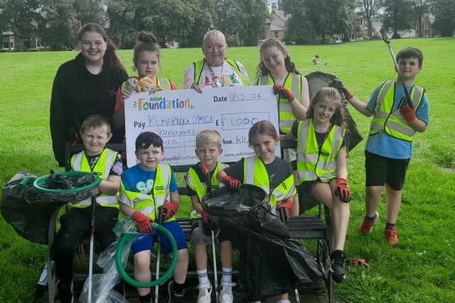 Asda Kilmarnock Community Champion, Teresa Bruce and Kilmarnock YMCA members after a litter pick in Kay Park, receiving an Asda Foundation cheque for the Young Futures Fund
