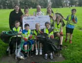 Asda Kilmarnock Community Champion, Teresa Bruce and Kilmarnock YMCA members after a litter pick in Kay Park, receiving an Asda Foundation cheque for the Young Futures Fund
