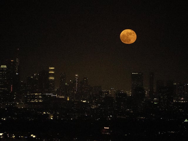 A supermoon rises above the skyline of downtown Los Angeles, Tuesday, June 14, 2022. The moon reached its full stage on Tuesday, during a phenomenon known as a supermoon because of its proximity to Earth, and it is also labelled as the "Strawberry Moon" because it is the full moon at strawberry harvest time. (AP Photo/Ringo H.W. Chiu)