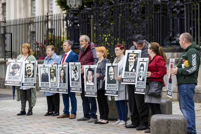 Families of those killed during the Ballymurphy Killings stand holding images of loved ones outside The Crown Court in Belfast