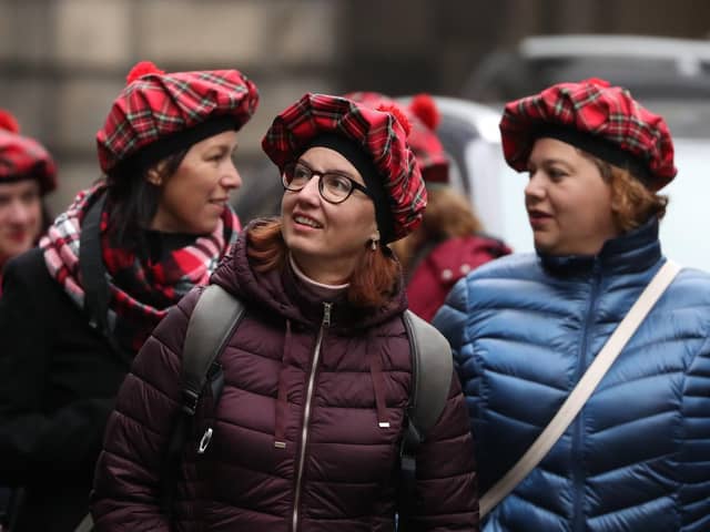 Tourists wearing tartan hats walk along the Royal Mile in Edinburgh. PA Photo. Picture: Andrew Milligan/PA Wire