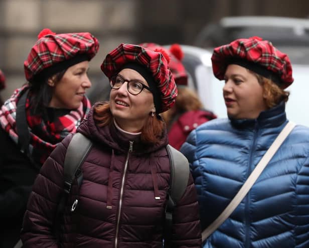 Tourists wearing tartan hats walk along the Royal Mile in Edinburgh. PA Photo. Picture: Andrew Milligan/PA Wire