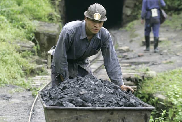 A miner pushes a cart containing coal out from a mine in Qianwei county in China's southwestern province of Sichuan, but should the UN continue to designate China and India as "developing nations". (Photo: LIU JIN/AFP via Getty Images)