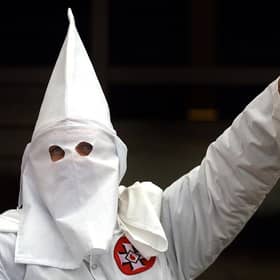 A Klansman raises his left arm during a "white power" chant at a Ku Klux Klan rally in 2000 (Getty Images)