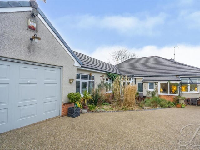 This image shows the handy garage, which is attached to the bungalow, and also the driveway, offering space for off-street parking.