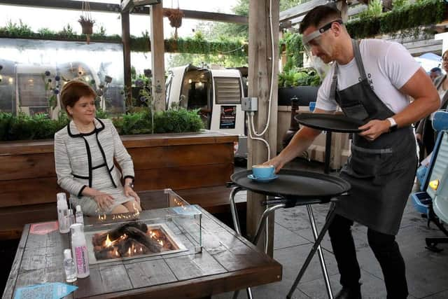 Nicola Sturgeon is served a coffee during a visit to the Cold Town House in Edinburgh's Grassmarket (Picture: Andrew Milligan/pool/AFP via Getty Images)