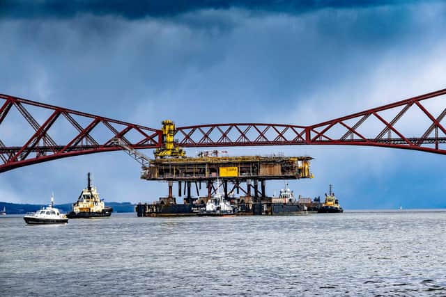 The Iron Lady barge with its cargo of a topside drilling platform for decommissioning being towed by Forth Ports tugs under the Forth Bridges into The Port of Rosyth on Sunday 11th April.  Credit: Peter Devlin