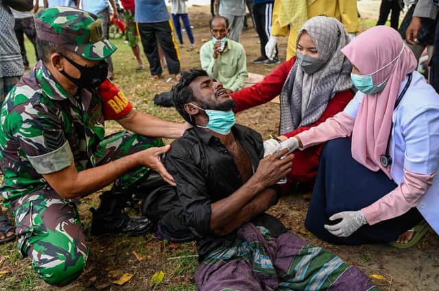 Health workers check a Rohingya refugee who was feeling sick after his arrival by boat in Krueng Raya, Indonesia's Aceh province on December 25, 2022. () (Photo by CHAIDEER MAHYUDDIN/AFP via Getty Images)