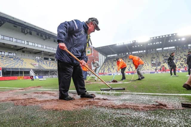 Stewards remove the rain and mud ahead of the U21 Euro qualifier between Belgium and Scotland, Sunday 05 June 2022 in Sint-Truiden. (Photo by BRUNO FAHY/BELGA MAG/AFP via Getty Images)