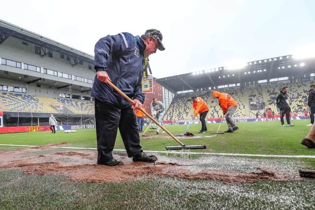 Stewards remove the rain and mud ahead of the U21 Euro qualifier between Belgium and Scotland, Sunday 05 June 2022 in Sint-Truiden.  (Photo by BRUNO FAHY/BELGA MAG/AFP via Getty Images)