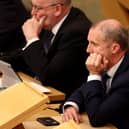 Former Cabinet Secretary for Health and Social Care Michael Matheson listens to First Minister John Swinney in the Scottish Parliament.