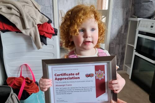 Two-year-old Alloweigh Frame receives an award for raising the alarm about a fire in a block of flats near her home in The Glebe, Lanark (Picture:: Kath McCabe/PA Wire)