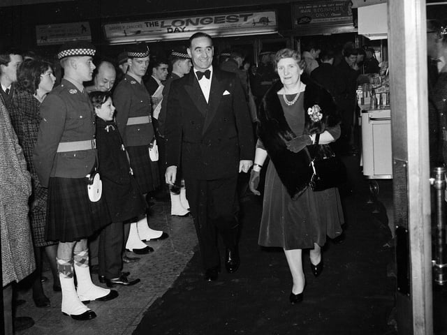 Hearts footballer Tommy Walker and his wife walk past a guard of honour at the premiere of film 'The Longest Day' at the New Victoria Cinema in February 1963.