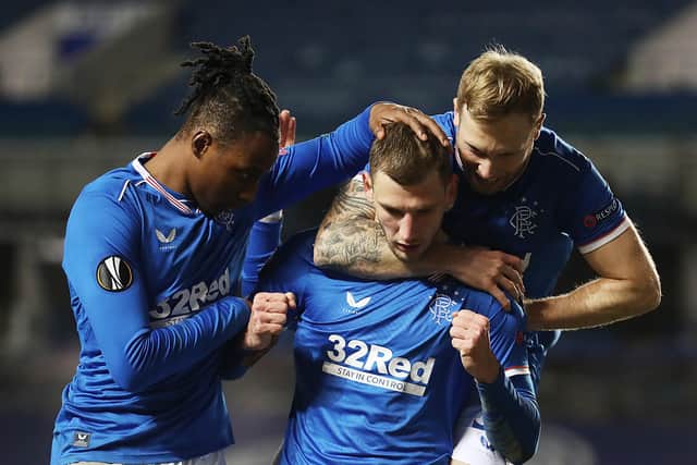 Borna Barisic of Rangers celebrates with Joe Aribo and Scott Arfield after he scores their fourth goa during the UEFA Europa League Round of 32 match between Rangers FC and Royal Antwerp FC at on February 25, 2021 in Glasgow, Scotland. (Photo by Ian MacNicol/Getty Images)