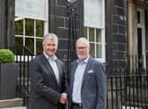 Scott Wallace and Steve Herkes shake hands on the deal.