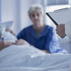A junior doctor speaks to an elderly patient