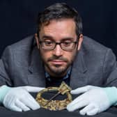 Dr Adrian Maldonado, Glenmorangie Research Fellow at National Museums Scotland, with the Hunterston Brooch, one of the museum's most prized medieval objects which features on the cover of a new book, Crucible of Nations: Scotland from Viking Age to Medieval Kingdom. The brooch was made around 700AD, using extremely sophisticated Irish-Scottish metalworking techniques. Some 200 years later, a Viking runic inscription was added of the Gaelic name Melbrigda. [image credit: Neil Hanna]"