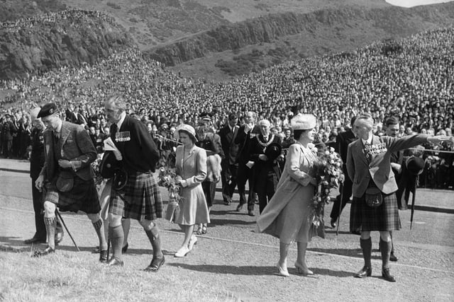 The Royal Party cross the road to the Saluting Base prior to the British Legion Parade at King's Park, Holyrood House, in 1946. King George VI is pictured with Queen Elizabeth and the then Princess Elizabeth in the centre.