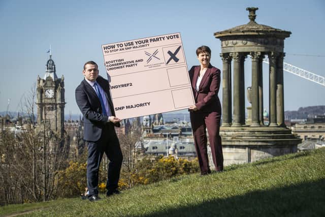 Scottish Conservative party leader Douglas Ross (left) and Ruth Davidson put a giant party list vote into a giant envelope on Calton Hill, Edinburgh during the election campaign.