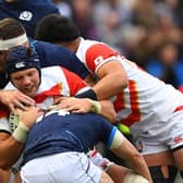 Japan's flanker Pieter Labuschagne (C) is tackled during the Autumn International friendly rugby union match between Scotland and Japan at Murrayfield Stadium in Edinburgh on November 20, 2021. (Photo by ANDY BUCHANAN/AFP via Getty Images)