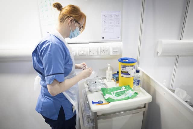 Nurse Eleanor Pinkerton prepares a coronavirus vaccine to be given to a health and care staff member at the NHS Louisa Jordan Hospital in Glasgow.