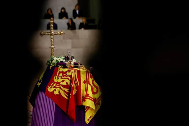 The coffin of Queen Elizabeth II, draped in the Royal Standard with the Imperial State Crown and the Sovereign's orb and sceptre, lying in state on the catafalque in Westminster Hall, at the Palace of Westminster, London. Picture date: Sunday September 18, 2022.