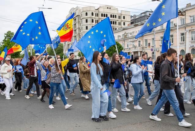 Young Moldovans waving EU and Moldovan flags take part in a march in Chisinau to celebrate Europe Day. Picture: Elena Covalenco/AFP