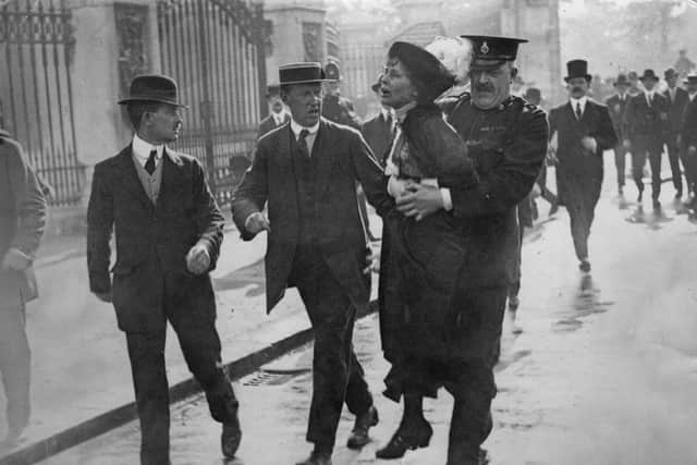 Outside Buckingham Palace, English suffragette Emmeline Pankhurst (1858 - 1928), is arrested and carried away by Superintendent Rolfe at a march, organised by Pankhurst, to petition King George V, London, 21st May 1914. On arrival at the palace, the marchers were met with force by the police and violence from the crowd of onlookers.  (Photo by Jimmy Sime/Central Press/Hulton Archive/Getty Images)