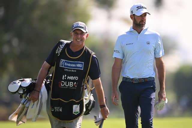 Scott Jamieson walks with his new caddie Phil "Wobbly" Morbey on the 18th hole on day one of the Hero Dubai Desert Classic at Emirates Golf Club. Picture: Ross Kinnaird/Getty Images.