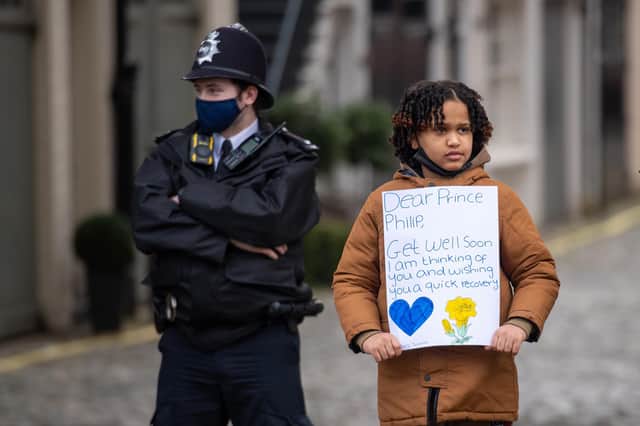 Twanna Saleh, 10, from London, with a 'get well soon' message for the Duke of Edinburgh, stands with police officers outside the King Edward VII Hospital in London, where the Duke of Edinburgh was admitted on Tuesday evening as a precautionary measure after feeling unwell picture: PA